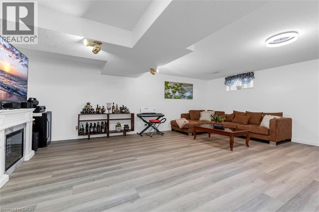Living room featuring a textured ceiling, light wood finished floors, and a high end fireplace - 51 Independence Drive, Hamilton, ON - Indoor With Fireplace