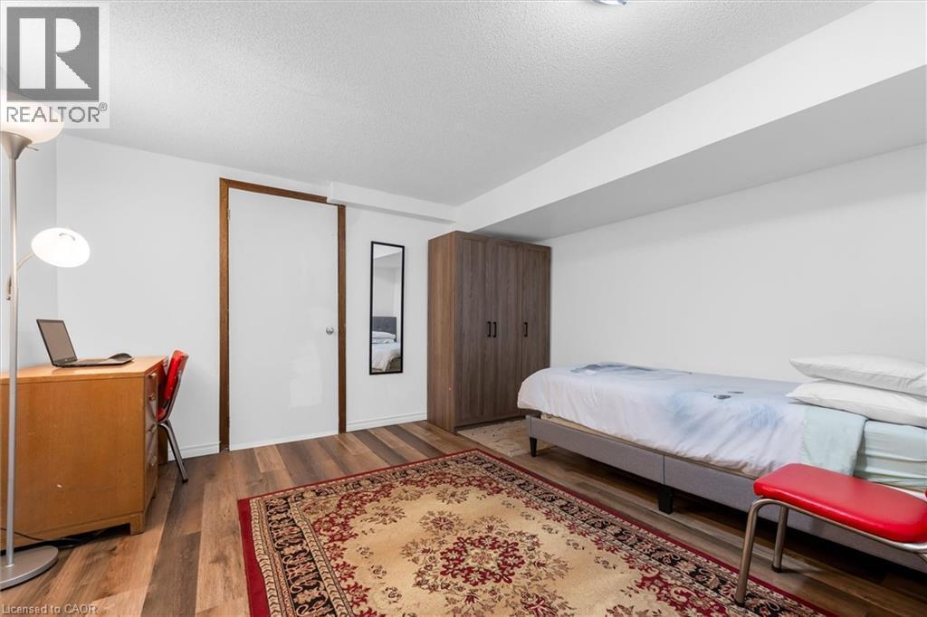 Bedroom featuring dark wood-type flooring, a textured ceiling, and a desk - 51 Independence Drive, Hamilton, ON - Indoor Photo Showing Bedroom