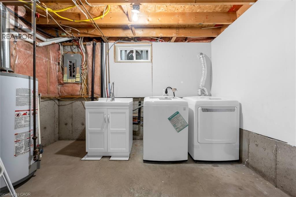Laundry area with concrete flooring, gas water heater, washing machine and clothes dryer, and electric panel - 51 Independence Drive, Hamilton, ON - Indoor Photo Showing Laundry Room