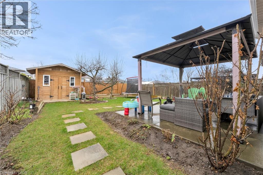 Fenced backyard featuring a patio, an outdoor hangout area, a gazebo, a trampoline, and a storage unit - 51 Independence Drive, Hamilton, ON - Outdoor