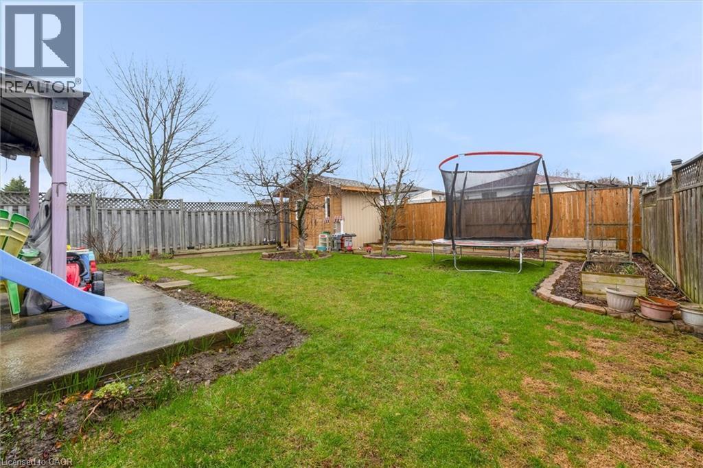 Fenced backyard with a trampoline and a patio area - 51 Independence Drive, Hamilton, ON - Outdoor With Backyard