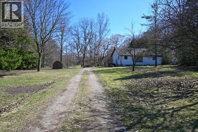 View of dirt / gravel driveway featuring view of wooded area - 1145 Main Street, Cambridge, ON - Outdoor