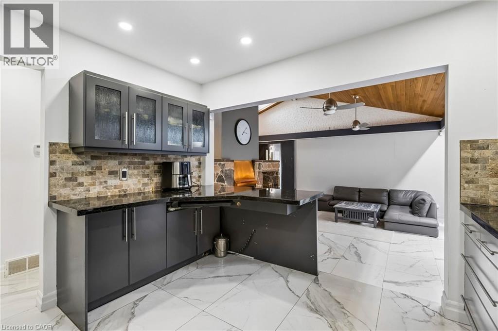 Kitchen with glass fronted cabinets, open floor plan, a ceiling fan, a peninsula, and vaulted ceiling - 3 Chicopee Terrace, Kitchener, ON - Indoor Photo Showing Kitchen