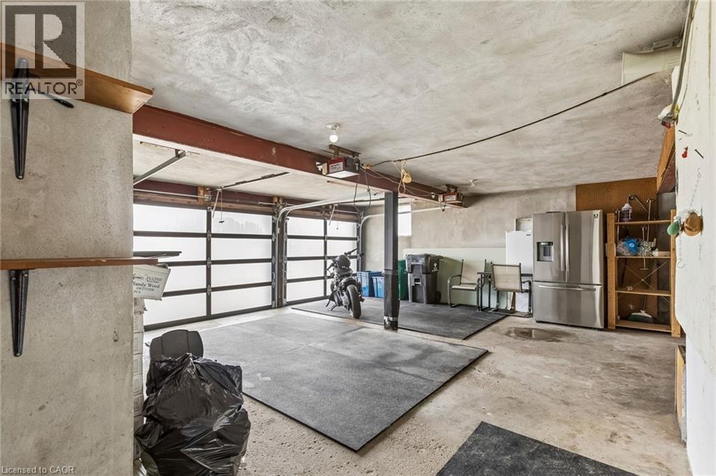 Garage with stainless steel refrigerator with ice dispenser - 3 Chicopee Terrace, Kitchener, ON - Indoor Photo Showing Garage