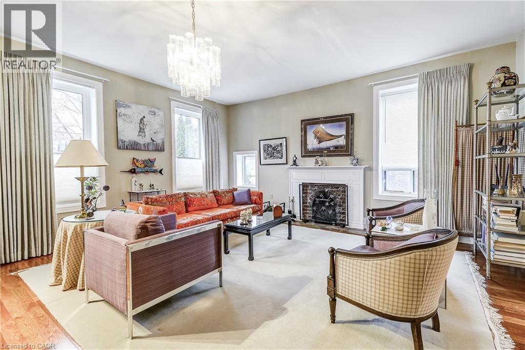 Living room with wood finished floors, a chandelier, and a premium fireplace - 315 Aberdeen Avenue, Hamilton, ON - Indoor Photo Showing Living Room With Fireplace