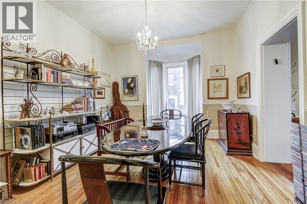 Dining room featuring light wood finished floors, suspended lighting, a decorative wall, and wainscoting - 315 Aberdeen Avenue, Hamilton, ON - Indoor Photo Showing Dining Room