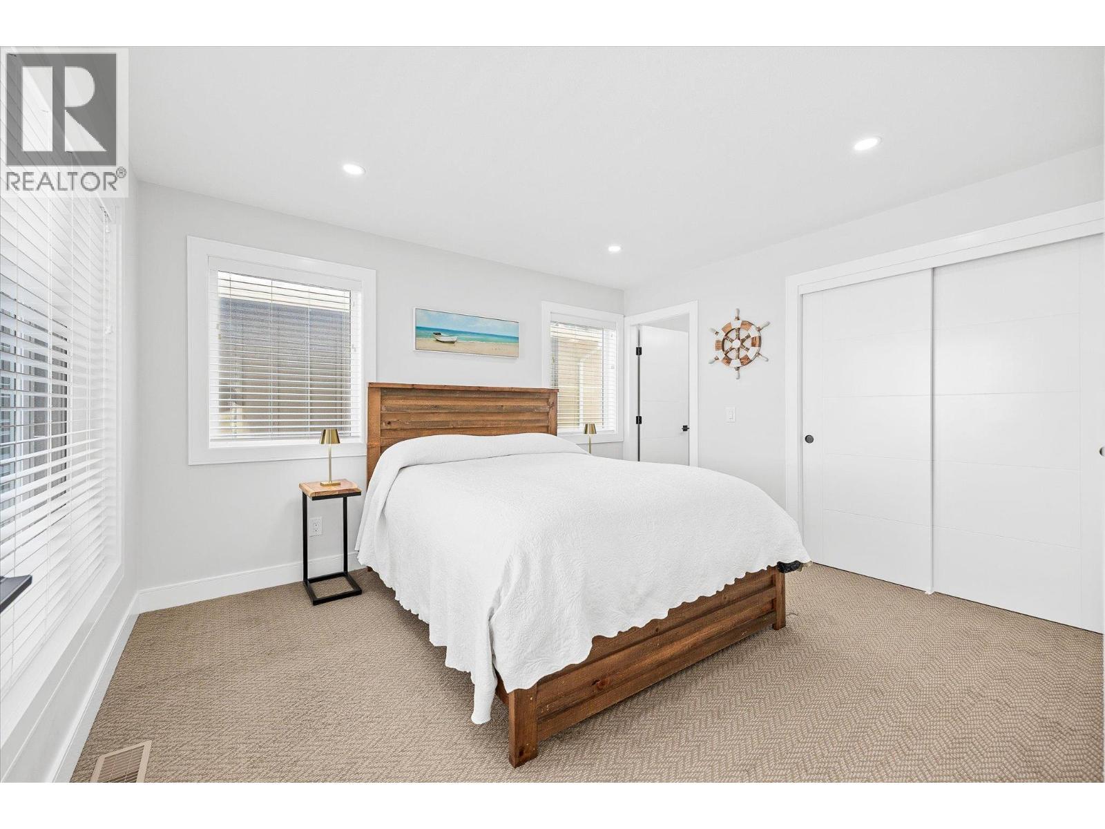 Main floor primary bedroom - 1860 Blue Bunch Court, Kelowna, BC - Indoor Photo Showing Bedroom