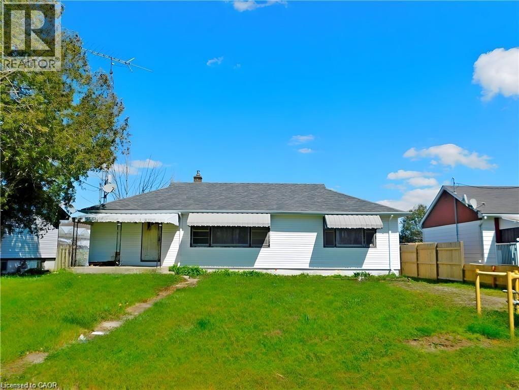 Rear view of house featuring a shingled roof and a chimney - 2474 Highway 24, Simcoe, ON