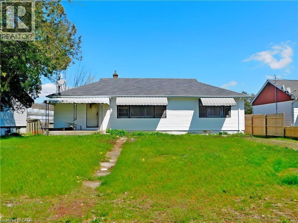 Rear view of house with a chimney, a porch, and roof with shingles - 2474 Highway 24, Simcoe, ON