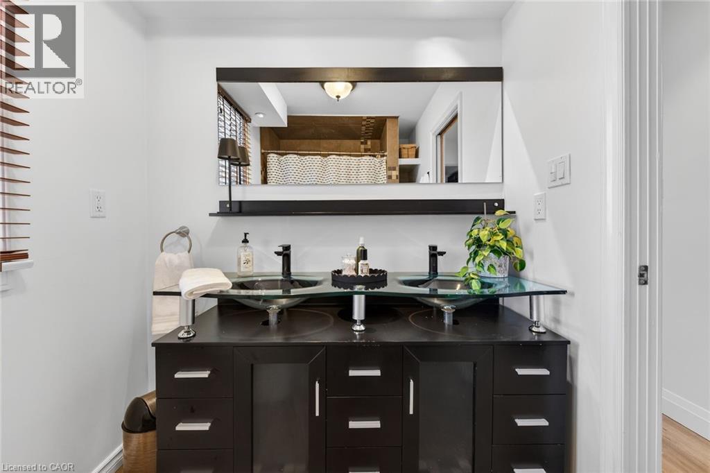 Full bath with double vanity, light tile patterned flooring, recessed lighting, and a shower with shower curtain - 844 Upper Wellington Street, Hamilton, ON - Indoor Photo Showing Bathroom