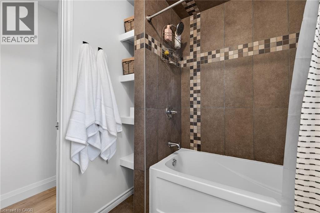 Bathroom with double vanity, a shower with curtain, and wood finished floors - 844 Upper Wellington Street, Hamilton, ON - Indoor Photo Showing Other Room