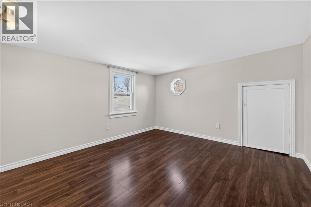 Empty room with dark wood-style flooring and baseboards - 844 Upper Wellington Street, Hamilton, ON - Indoor Photo Showing Other Room