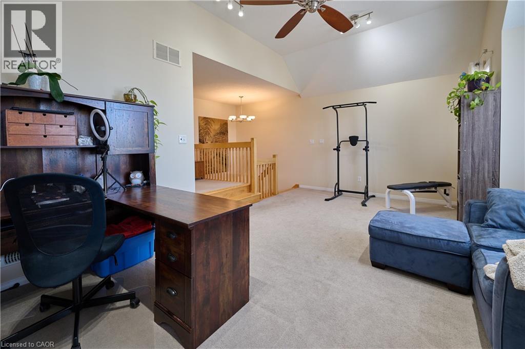 Home office with light colored carpet, ceiling fan, hanging lights, and lofted ceiling - 126 Snowdrop Crescent, Kitchener, ON - Indoor Photo Showing Office