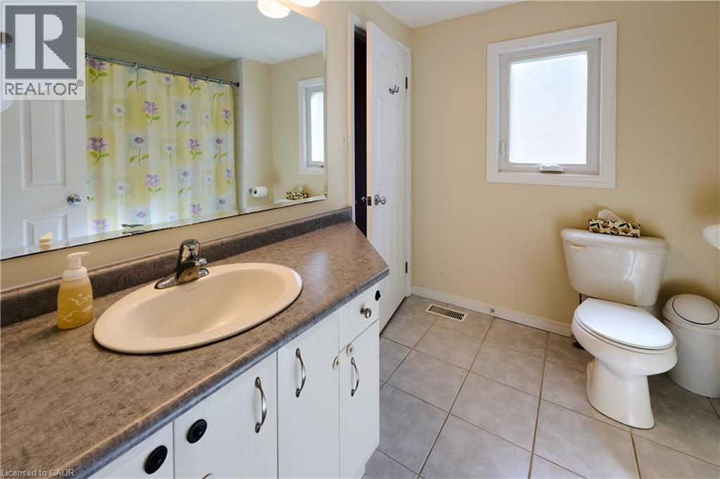 Bathroom with vanity, a shower with shower curtain, and light tile patterned floors - 126 Snowdrop Crescent, Kitchener, ON - Indoor Photo Showing Bathroom