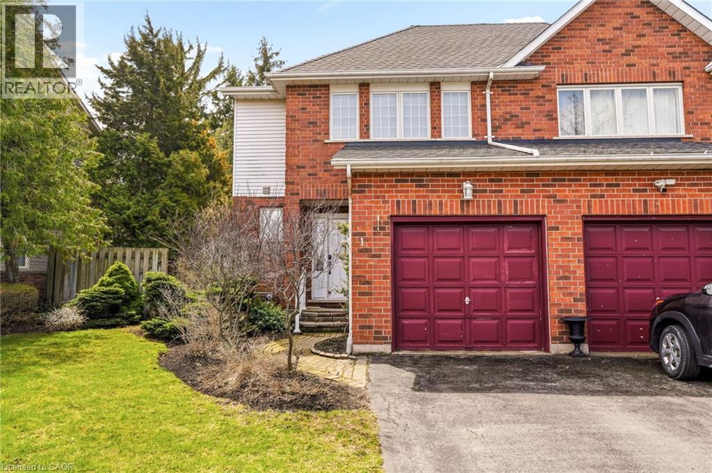 The property features a brick exterior, a driveway, and two garage doors - 1 Tomahawk Drive, Grimsby, ON - Outdoor