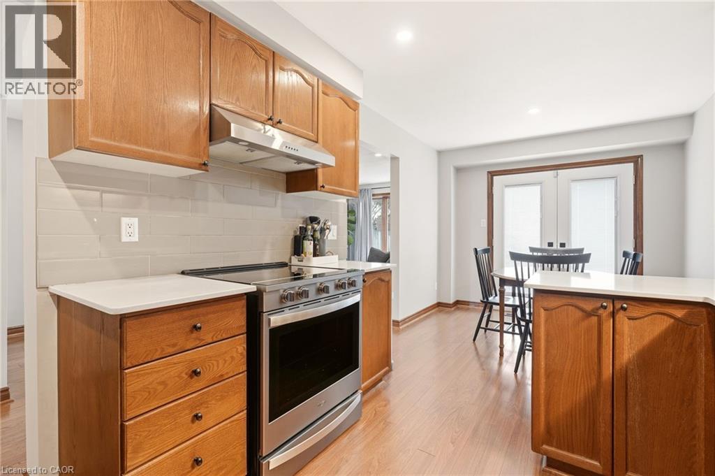 The kitchen features wood cabinetry, white countertops, a light-colored subway tile backsplash, and stainless steel appliances - 1 Tomahawk Drive, Grimsby, ON - Indoor Photo Showing Kitchen