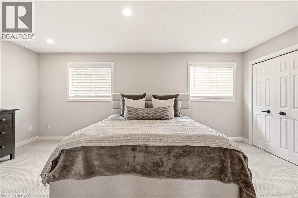 The property features recessed lighting, two windows with blinds, and light-colored carpeting - 1 Tomahawk Drive, Grimsby, ON - Indoor Photo Showing Bedroom