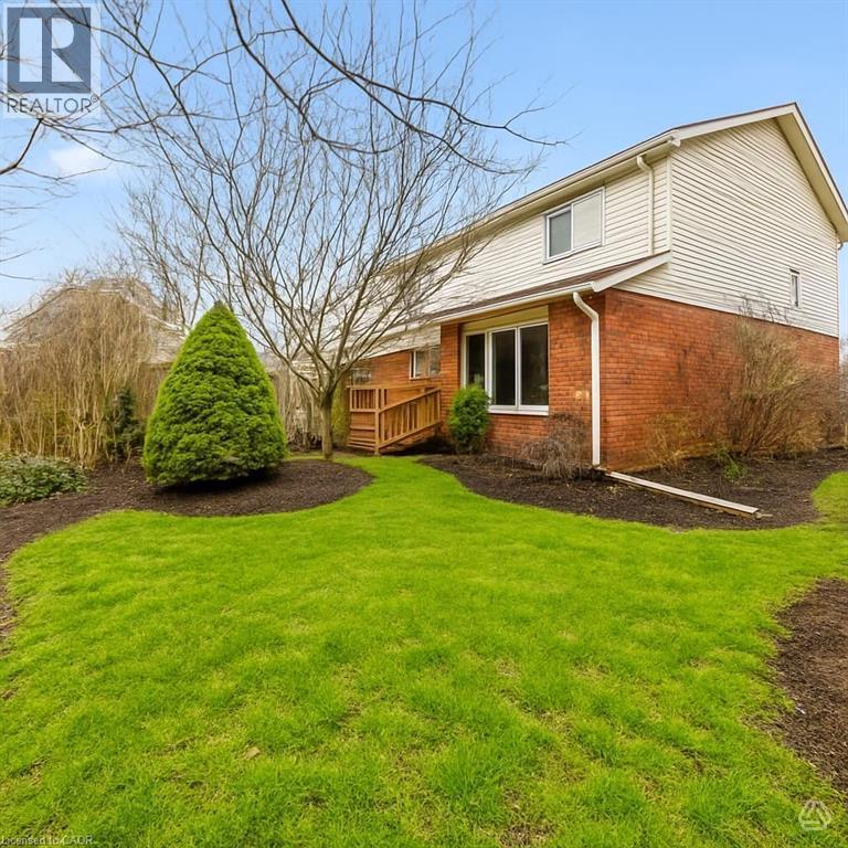 The property features a brick and siding exterior, a well-maintained lawn, and established landscaping - 1 Tomahawk Drive, Grimsby, ON - Outdoor