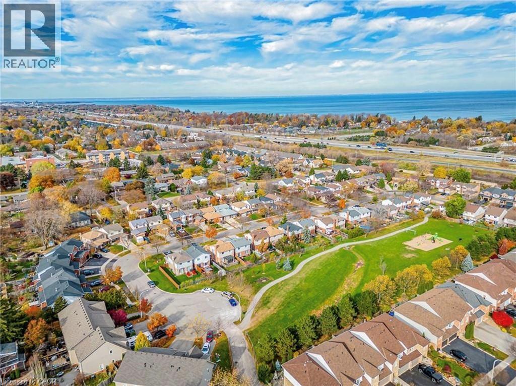 Aerial view showcasing the residential area with a prominent body of water in the background and a well-maintained green space - 1 Tomahawk Drive, Grimsby, ON - Outdoor With View