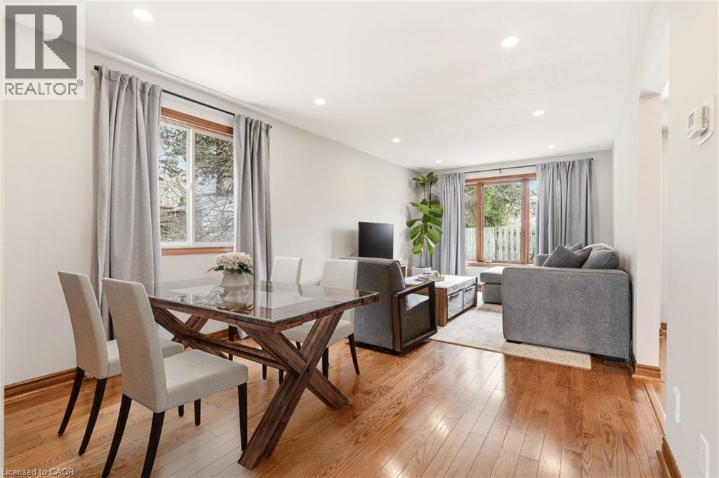 The property features a bright living area with hardwood flooring, recessed lighting, and large windows with privacy drapes - 1 Tomahawk Drive, Grimsby, ON - Indoor