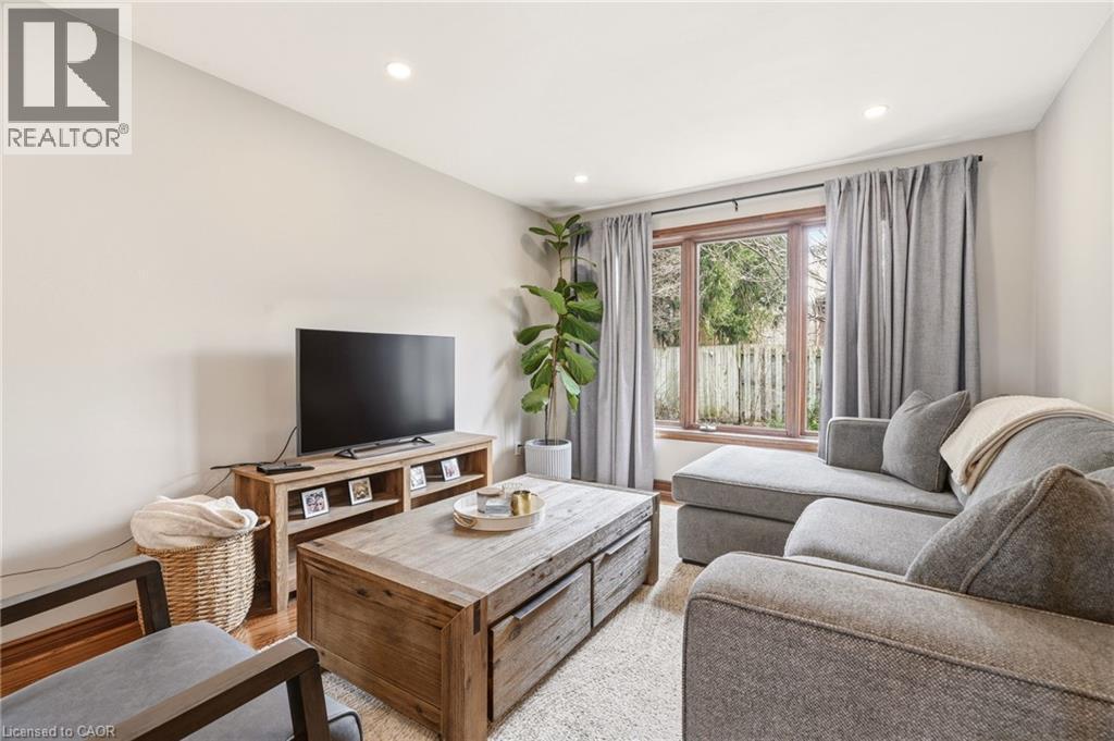 Living area featuring light-colored walls, recessed lighting, and a window with a view of outdoor greenery - 1 Tomahawk Drive, Grimsby, ON - Indoor Photo Showing Living Room