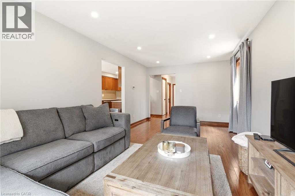 The living area features hardwood flooring, recessed lighting, and light-colored walls - 1 Tomahawk Drive, Grimsby, ON - Indoor Photo Showing Living Room