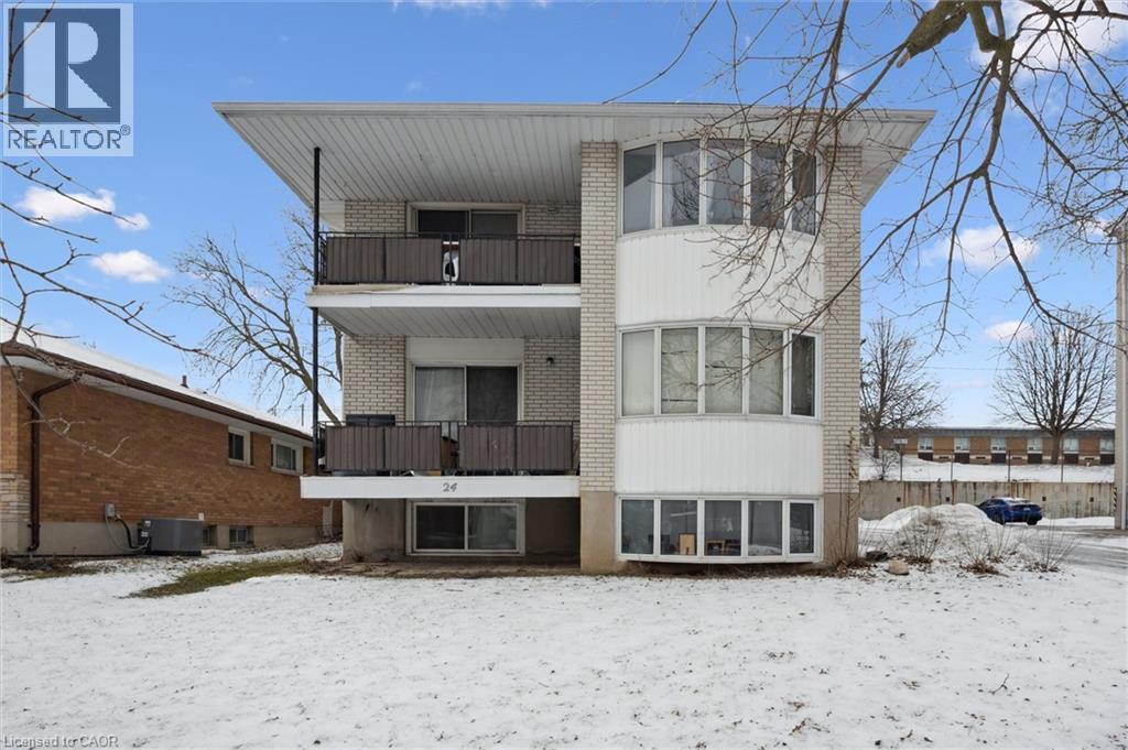 The property features a multi-story building with light-colored brick and white siding accents - 24 Austin Drive, Waterloo, ON - Outdoor