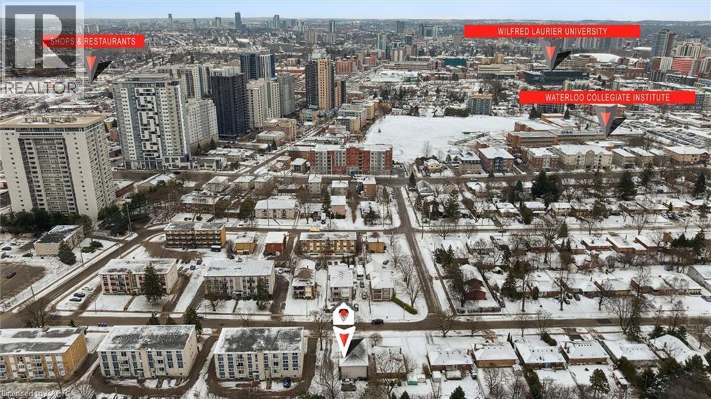 Aerial view showcasing the surrounding neighborhood with residential properties, urban infrastructure, and distant city buildings - 24 Austin Drive, Waterloo, ON - Outdoor With View