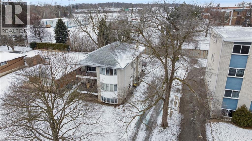 The property features a multi-story building with a grey shingle roof and a prominent bay window design on one facade - 24 Austin Drive, Waterloo, ON - Outdoor