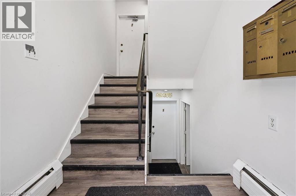 Entryway featuring a staircase with wood-look treads, a metal handrail, and white walls - 24 Austin Drive, Waterloo, ON - Indoor Photo Showing Other Room