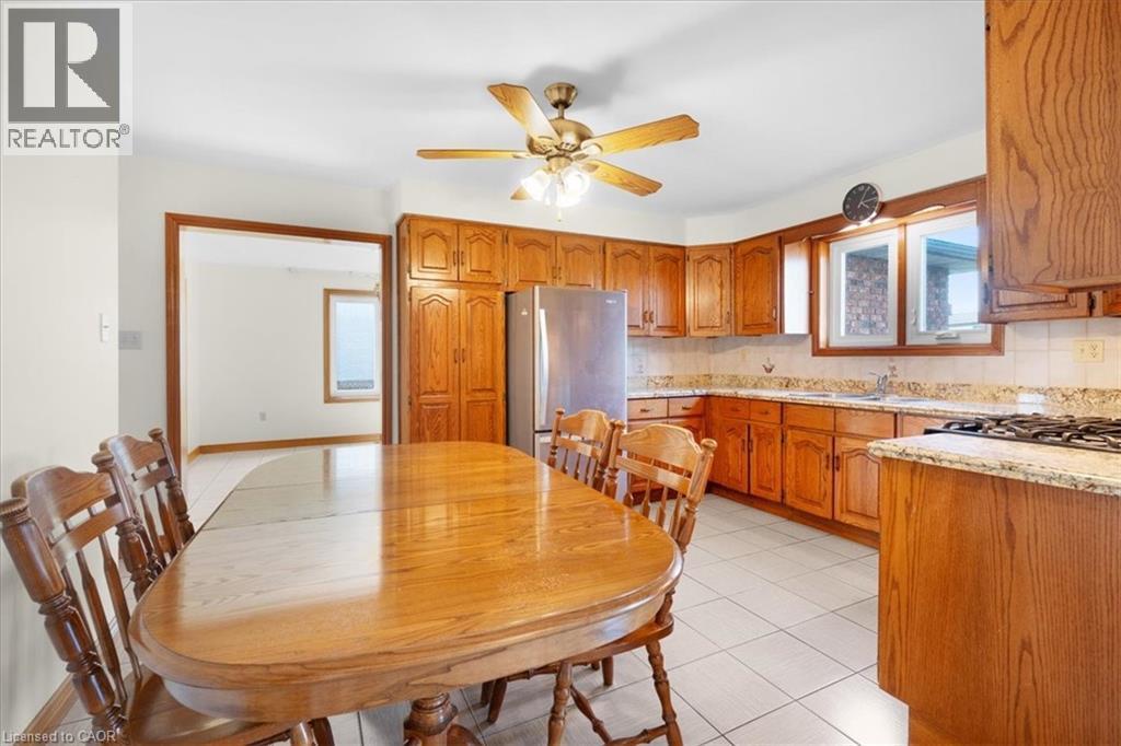 The kitchen features wood cabinetry, granite countertops, and tile flooring - 18 Marcel Place, Hamilton, ON - Indoor Photo Showing Other Room