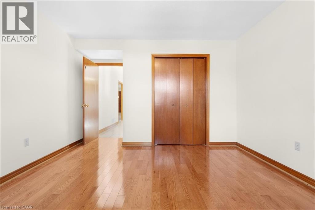 This room features polished hardwood flooring and light-colored walls - 18 Marcel Place, Hamilton, ON - Indoor Photo Showing Other Room