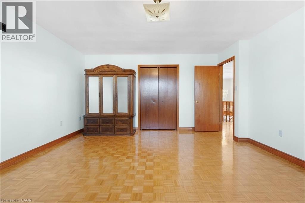 This room features parquet flooring, white walls, and a ceiling light fixture - 18 Marcel Place, Hamilton, ON - Indoor Photo Showing Other Room