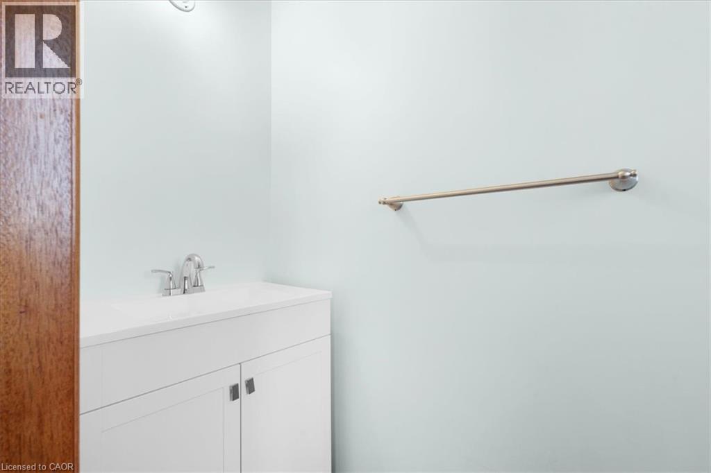 Bathroom vanity featuring a white countertop with an integrated sink and chrome faucet - 18 Marcel Place, Hamilton, ON - Indoor Photo Showing Bathroom