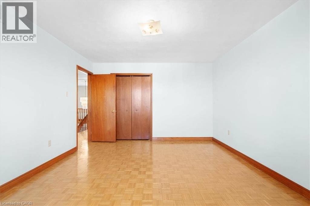 This room features parquet flooring, light-colored walls, and a ceiling light fixture - 18 Marcel Place, Hamilton, ON - Indoor Photo Showing Other Room