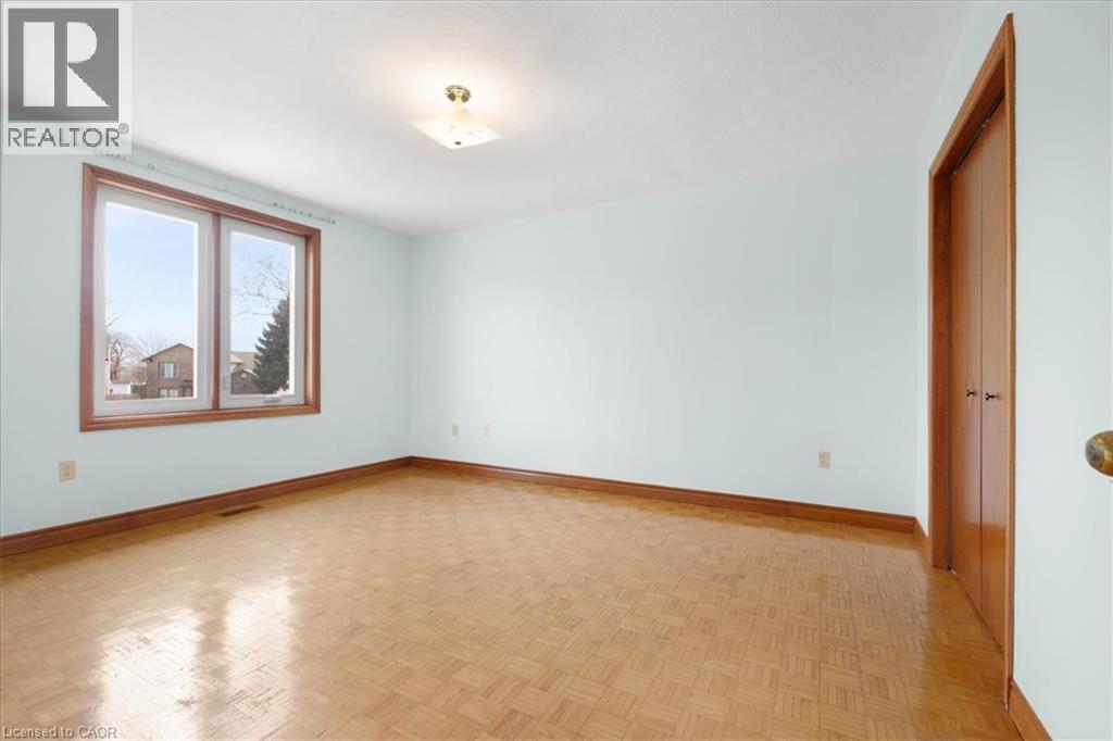 This room features parquet flooring, light blue walls, and a window with a wood frame - 18 Marcel Place, Hamilton, ON - Indoor Photo Showing Other Room