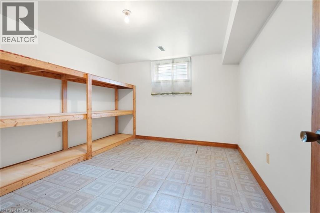 The property offers a dedicated storage area with built-in wooden shelving units - 18 Marcel Place, Hamilton, ON - Indoor Photo Showing Other Room