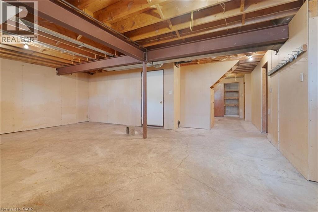 The property features an unfinished basement with exposed wooden joists, concrete flooring, and structural steel beams - 18 Marcel Place, Hamilton, ON - Indoor Photo Showing Basement