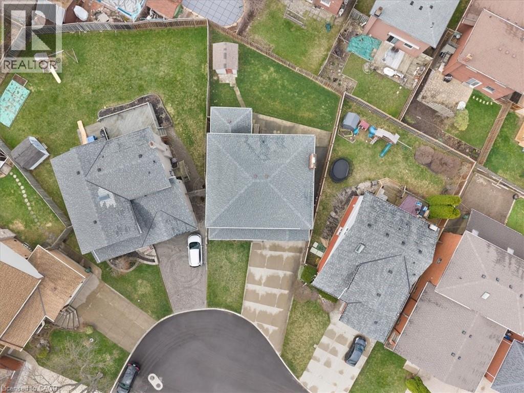 Aerial view showcasing the property's cul-de-sac location with a driveway, a fully fenced backyard with a lawn, and a shed - 18 Marcel Place, Hamilton, ON - With View