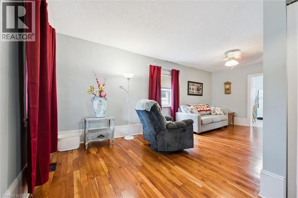 This living space features hardwood floors, light-colored walls, and a ceiling fan - 28 Davidson Street, Cambridge, ON - Indoor Photo Showing Living Room