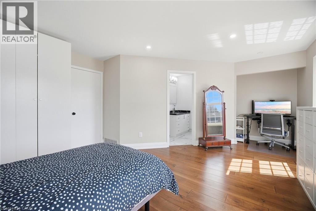 This room features hardwood floors, recessed lighting, and white built-in cabinetry - 38 Leclaire Street, Hamilton, ON - Indoor Photo Showing Bedroom