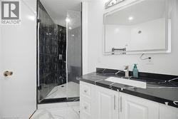 The bathroom features a sleek vanity with a dark countertop and an undermount sink, complemented by a modern faucet -