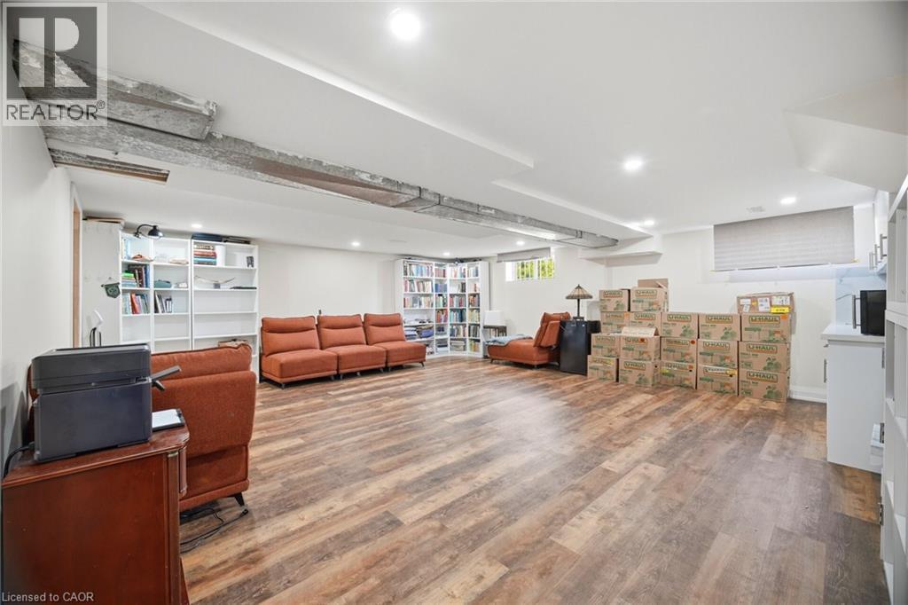 Spacious room featuring wood-look flooring, recessed lighting, and built-in shelving - 38 Leclaire Street, Hamilton, ON - Indoor