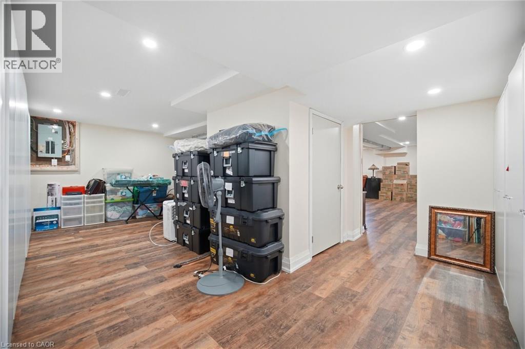 Spacious room featuring wood-look flooring, white walls, and recessed lighting - 38 Leclaire Street, Hamilton, ON - Indoor