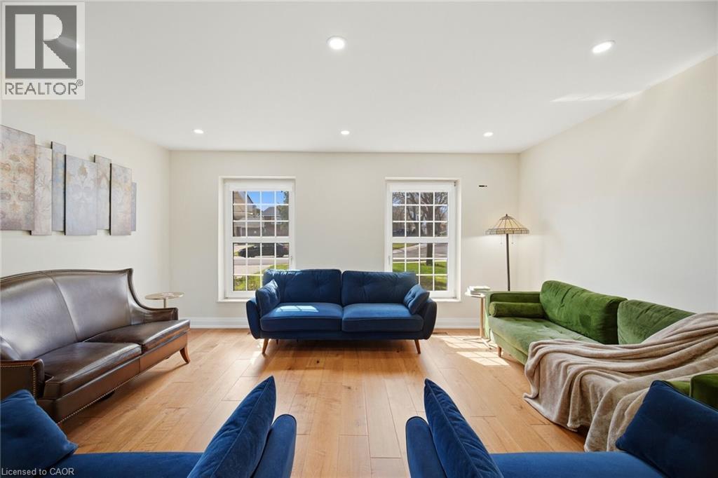 The living area features hardwood floors and two windows that provide natural light - 38 Leclaire Street, Hamilton, ON - Indoor Photo Showing Living Room