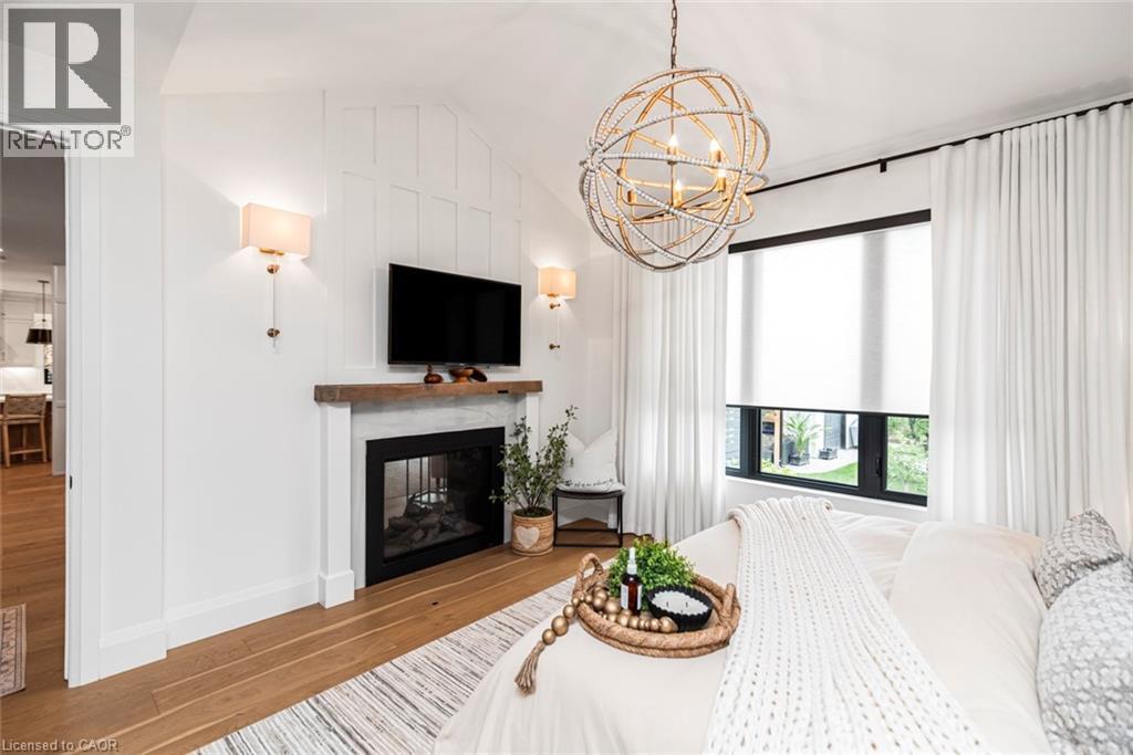 Recessed fireplace with a wood-finish mantel and stone surround - 253 Central Avenue, Grimsby, ON
