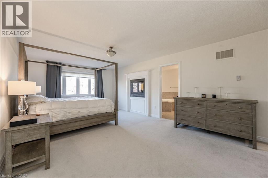 This property features a spacious room with light-colored carpeting, multiple windows, and an entryway leading to another room - 2453 Village Common, Oakville, ON - Indoor Photo Showing Bedroom