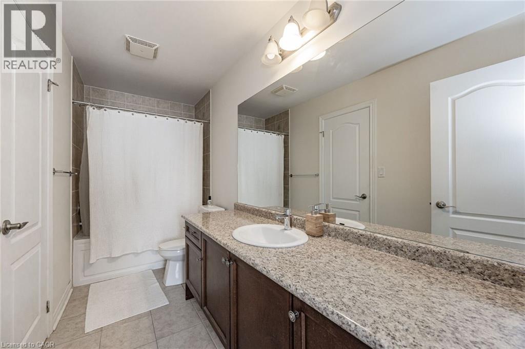 Bathroom featuring a vanity with a light-colored countertop, an integrated sink, and a large mirror - 2453 Village Common, Oakville, ON - Indoor Photo Showing Bathroom