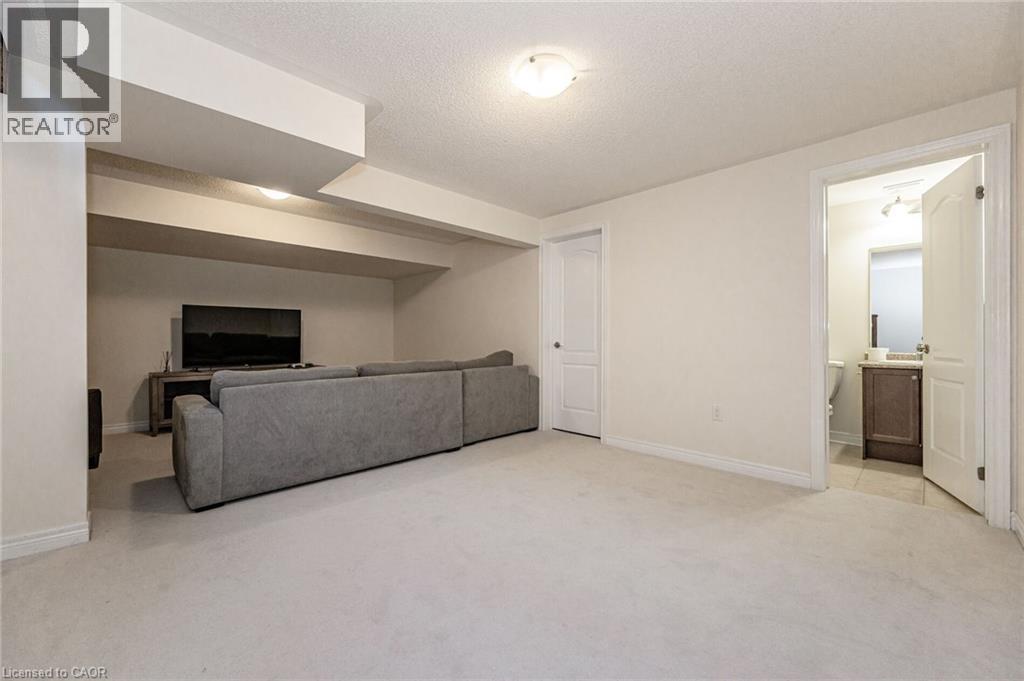 Expansive room featuring light-colored carpeting, recessed lighting, and a white door leading to a bathroom with a vanity and tiled flooring - 2453 Village Common, Oakville, ON - Indoor Photo Showing Other Room