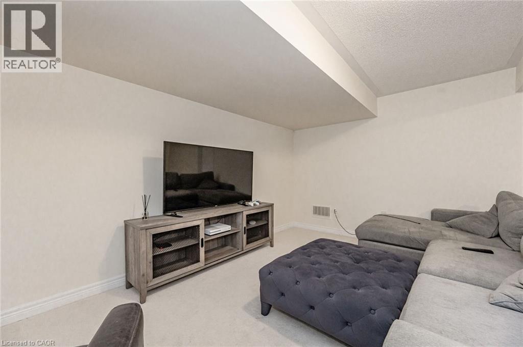 This living space features light-colored walls and carpeted flooring - 2453 Village Common, Oakville, ON - Indoor